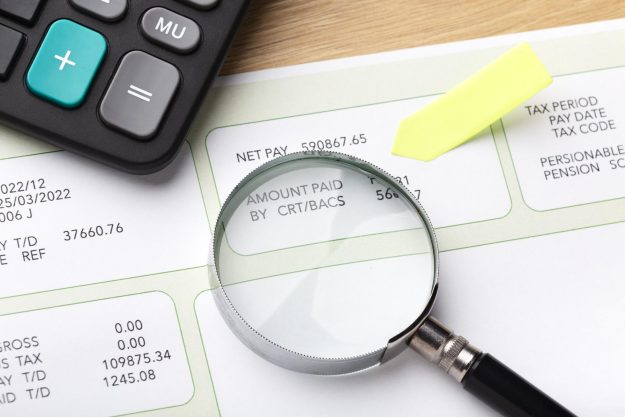 rsu-withholding-gap Magnifying glass over a payroll stub